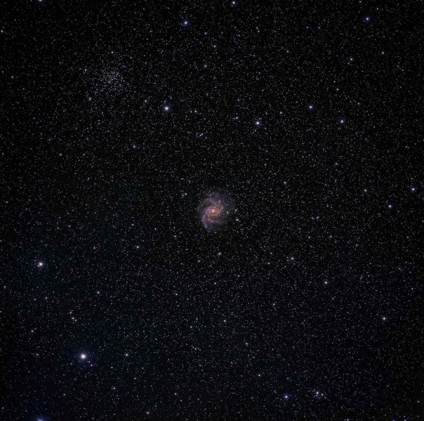 Spiral galaxy with a bright orange core and blue arms.